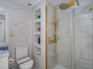 a white bathroom with a shower and a toilet at Apartment Marbella Real by Interhome in Marbella