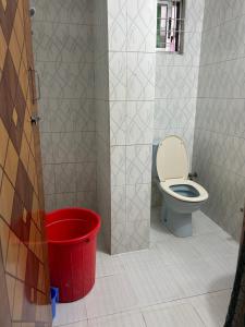 a bathroom with a toilet and a bucket at ASIF's Residence In Newmarket in Dhaka