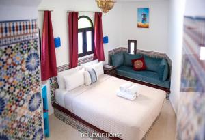 BELLEVUE HOUSE - with terrace in the heart of medina في شفشاون: غرفة نوم بسرير واريكة خضراء