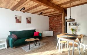 a living room with a green couch and a table at Stara Piekarnia Tolkmicko in Tolkmicko