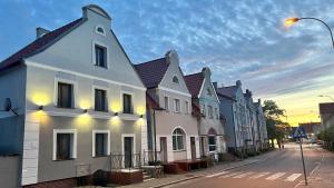 a row of houses on a street at sunset at Stara Piekarnia Tolkmicko in Tolkmicko