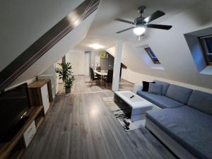 sala de estar con sofá azul y ventilador de techo en Gamlitz - Eckberg, en Gamlitz