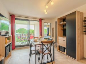 uma cozinha e sala de jantar com mesa e cadeiras em Apartment Les Balcons de l'Atlantique-12 by Interhome em Pontaillac