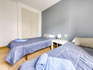 ロザスにあるApartment Mismar-5 by Interhomeのベッドルーム1室(ベッド2台、ランプ付きテーブル付)