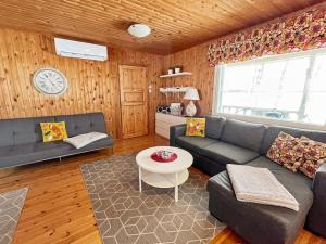 een woonkamer met een bank en een tafel bij Holiday Home Villa piranniemi by Interhome in Onkamon Kannas