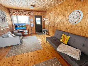 een woonkamer met een bank en een klok aan de muur bij Holiday Home Villa piranniemi by Interhome in Onkamon Kannas +16 foto's