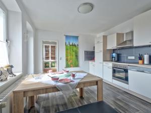 una cocina con una mesa de madera con cuencos. en Apartment Mönkemeierhof by Interhome, en Schieder-Schwalenberg