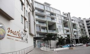 a large apartment building with cars parked in front of it at SUPER MARES_Comfortable & Cozy Apartment in Maputo