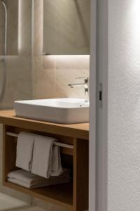 a bathroom with a white sink and a mirror at Zur Brücke in Mittewald - Your home in heart of South Tyrol, with Brixencard and free parking, ideal starting point for unforgettable excursions and outdoor adventures in Fortezza