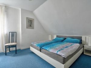 a bedroom with a bed and a chair at Apartment Am Brauamt-Am Malerwinkel by Interhome in Schieder-Schwalenberg