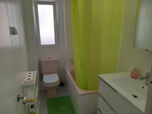 a bathroom with a green shower curtain and a toilet at Helle moderne Ferienwohnung 500m v.Meer in Almería