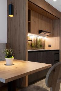 a kitchen with a wooden table with a potted plant on it at Zur Brücke in Mittewald - Your home in heart of South Tyrol, with Brixencard and free parking, ideal starting point for unforgettable excursions and outdoor adventures in Fortezza
