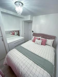 a bedroom with two beds and a chandelier at 2 Bed Flat, Dalston Junction, London in London