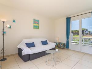 a living room with a bed and a balcony at Villa Les Pesquiers by Interhome in Hyères