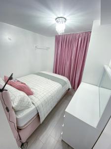 a bedroom with a bed with a red curtain at 2 Bed Flat, Dalston Junction, London in London