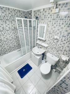 a bathroom with a toilet and a tub and a sink at 2 Bed Flat, Dalston Junction, London in London