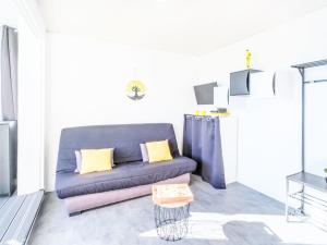 a living room with a blue couch and a table at Studio Port Arcachon-2 by Interhome in Arcachon
