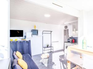 a living room with a blue couch and yellow pillows at Studio Port Arcachon-2 by Interhome in Arcachon +20 photos