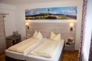 BermuthshainDeutsches Haus Hotel Restaurant Gastwirtschaft Biergarten am Radweg Bermuthshain的卧室里有一张床，墙上挂着一幅画