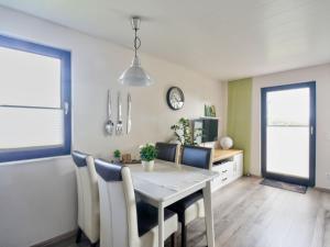 a dining room with a white table and chairs at Holiday Home Merle by Interhome in Vörden