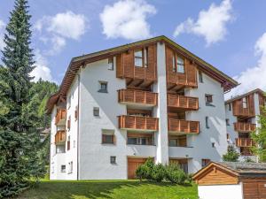 ein weißes Apartmenthaus mit Holzbalkonen in der Unterkunft Apartment Chesa Maurus A5 by Interhome in St. Moritz
