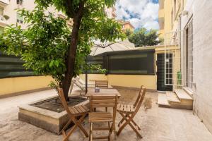 un patio con tavolo, sedie e un albero di LoveRhome Apartment 1 a Roma