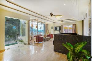 Levelup Plus Pinaaki Inn في ريشيكيش: غرفة معيشة مع نافذة كبيرة وأريكة