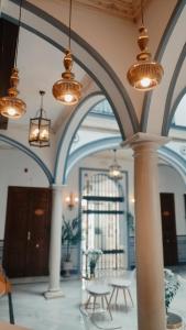 a lobby with tables and chandeliers in a building at Casa Palacio Don Pedro in Seville