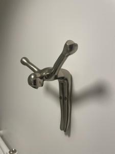 a metal faucet hanging on a white wall at Chambre suite privée à Boulogne in Boulogne-Billancourt