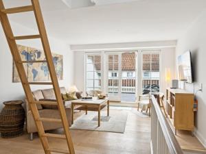 Una escalera en una sala de estar con sofá y mesa en Apartment Galia - 2km from the sea in Sealand by Interhome, en Rørvig