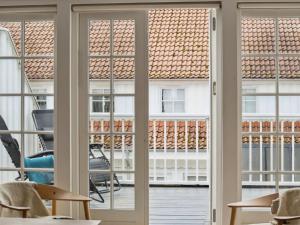 een kamer met glazen schuifdeuren en uitzicht op een gebouw bij Apartment Galia - 2km from the sea in Sealand by Interhome in Rørvig