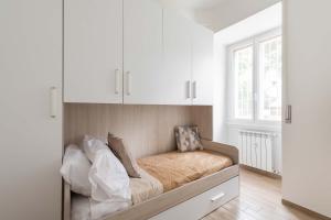 un letto in una camera con armadi bianchi di LoveRhome Apartment 1 a Roma