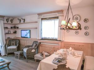 a dining room with a table and chairs and a chandelier at Apartment Chesa Tschierv II 30 by Interhome in Celerina