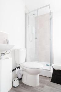 a white bathroom with a toilet and a shower at 4 bed house parking Wi-Fi garden in Wallasey