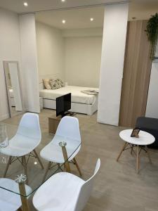 a living room with white chairs and a bed at Exyca Tetuán in Madrid