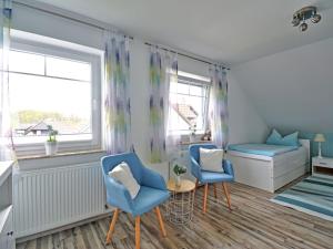 Habitación con 2 sillas azules y 1 cama en Apartment Lona by Interhome, en Lothe