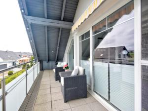 a balcony with chairs and a large window at Apartment Lona by Interhome in Lothe