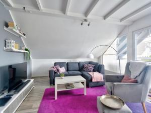 a living room with a couch and a tv at Apartment Lona by Interhome in Lothe