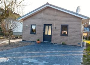 a small house with a blue door on a driveway at Ferienhaus Kalle 55180 in Detern