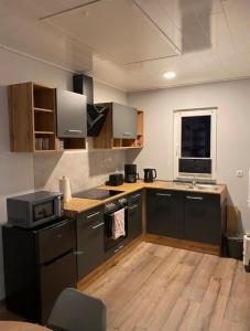 uma cozinha com um lavatório e um fogão forno superior em Ferienhaus Kalle 55180 em Detern