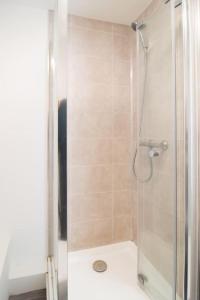 a shower with a glass door in a bathroom at 4 bed house parking Wi-Fi garden in Wallasey