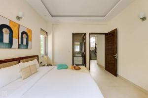 a bedroom with a large white bed in a room at Ra-3Bed Villa W/PVTpool in Assagao by Masaya Stays in Verla