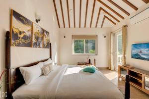 1 dormitorio con 1 cama grande y TV en Ra-3Bed Villa W/PVTpool in Assagao by Masaya Stays, en Verla