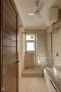 baño con ducha, aseo y puerta en Ra-3Bed Villa W/PVTpool in Assagao by Masaya Stays, en Verla