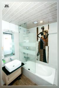 ein Badezimmer mit einem Waschbecken, einer Badewanne und einem Spiegel in der Unterkunft Hotel Maya Boutique and Apartment, Thamel in Kathmandu