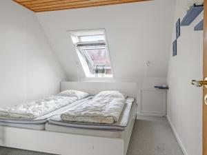 - 2 lits dans une petite chambre avec fenêtre dans l'établissement Holiday Home Minte - 450m from the sea in NW Jutland by Interhome, à Skagen