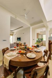 a dining room with a wooden table and chairs at Ra-3Bed Villa W/PVTpool in Assagao by Masaya Stays in Verla