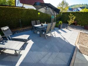 a patio with a table and chairs and an umbrella at Holiday Home Mia by Interhome in Lügde