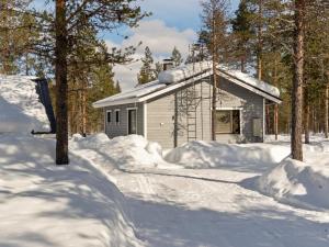 um edifício coberto de neve junto às árvores em Holiday Home Riekko by Interhome em Enontekiö