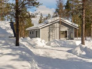 a building covered in snow next to trees at Holiday Home Riekko by Interhome in Enontekiö